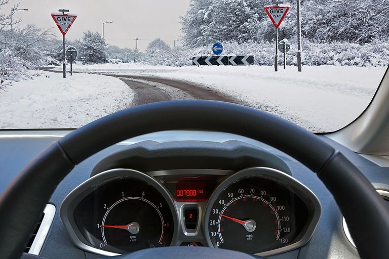 car-dashboard-steering-wheel-view-of-snowy-road-roundabout