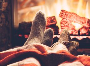 people-putting-their-feet-up-to-a-warm-fire