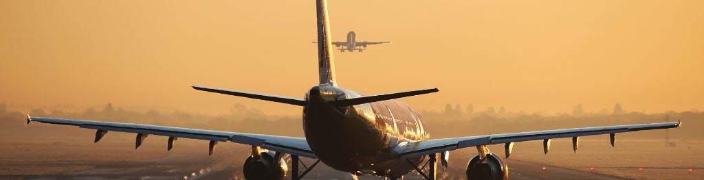 A plane about to take off amid a red sky background.