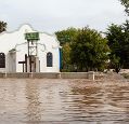 white building next to trees in flood water