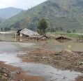 houses in rural area in Ruanda being flooded, tops of buildings coming out of water