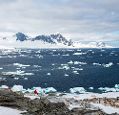 A panoramic view of the Antarctic coastline and sea with sea ice on the surface.