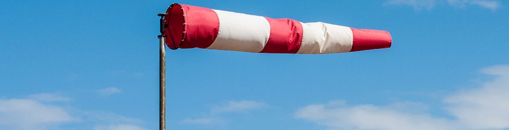 A wind sock blowing in the wind at an airport.