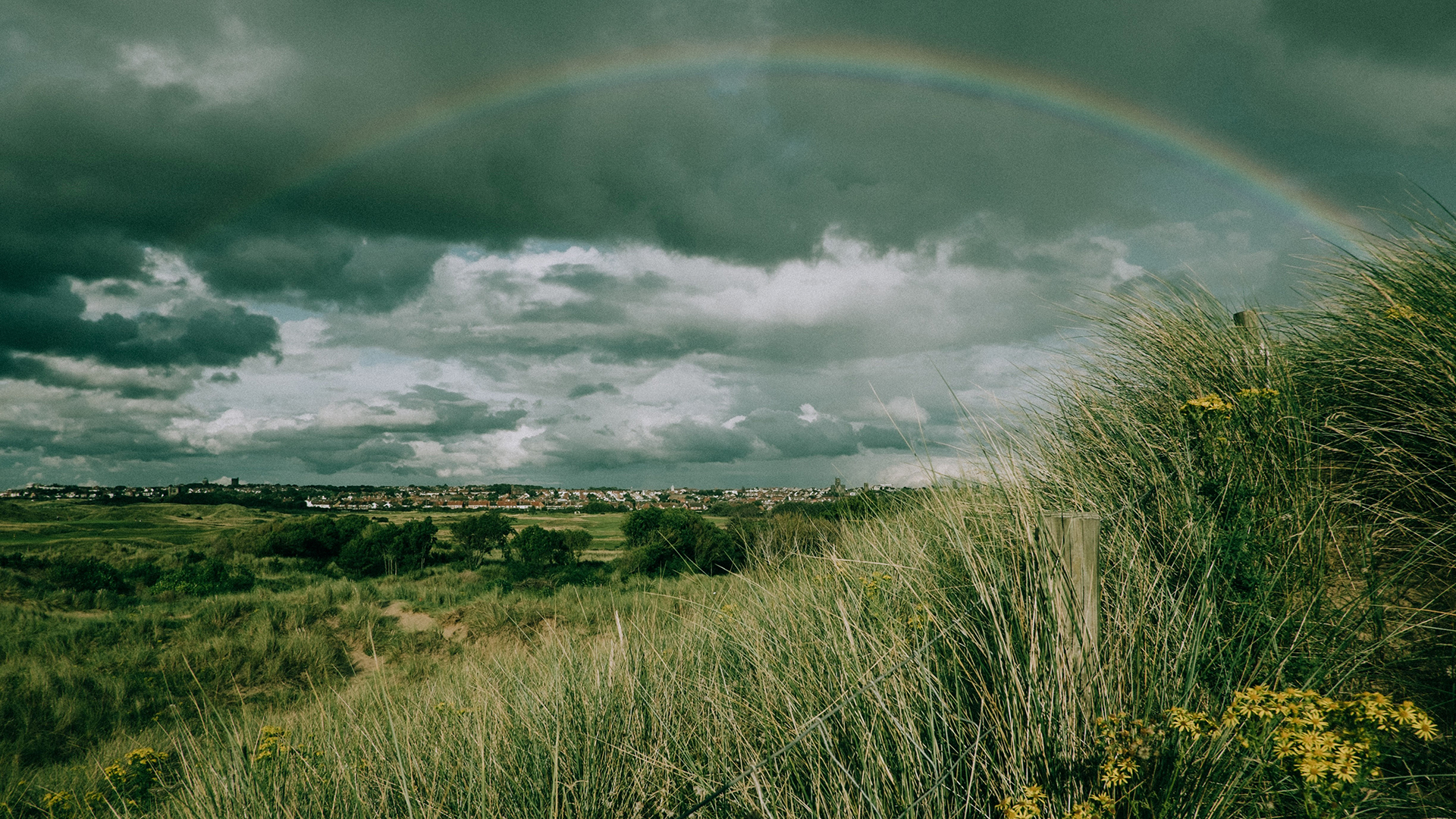 Overcast grey skies with a rainbow.