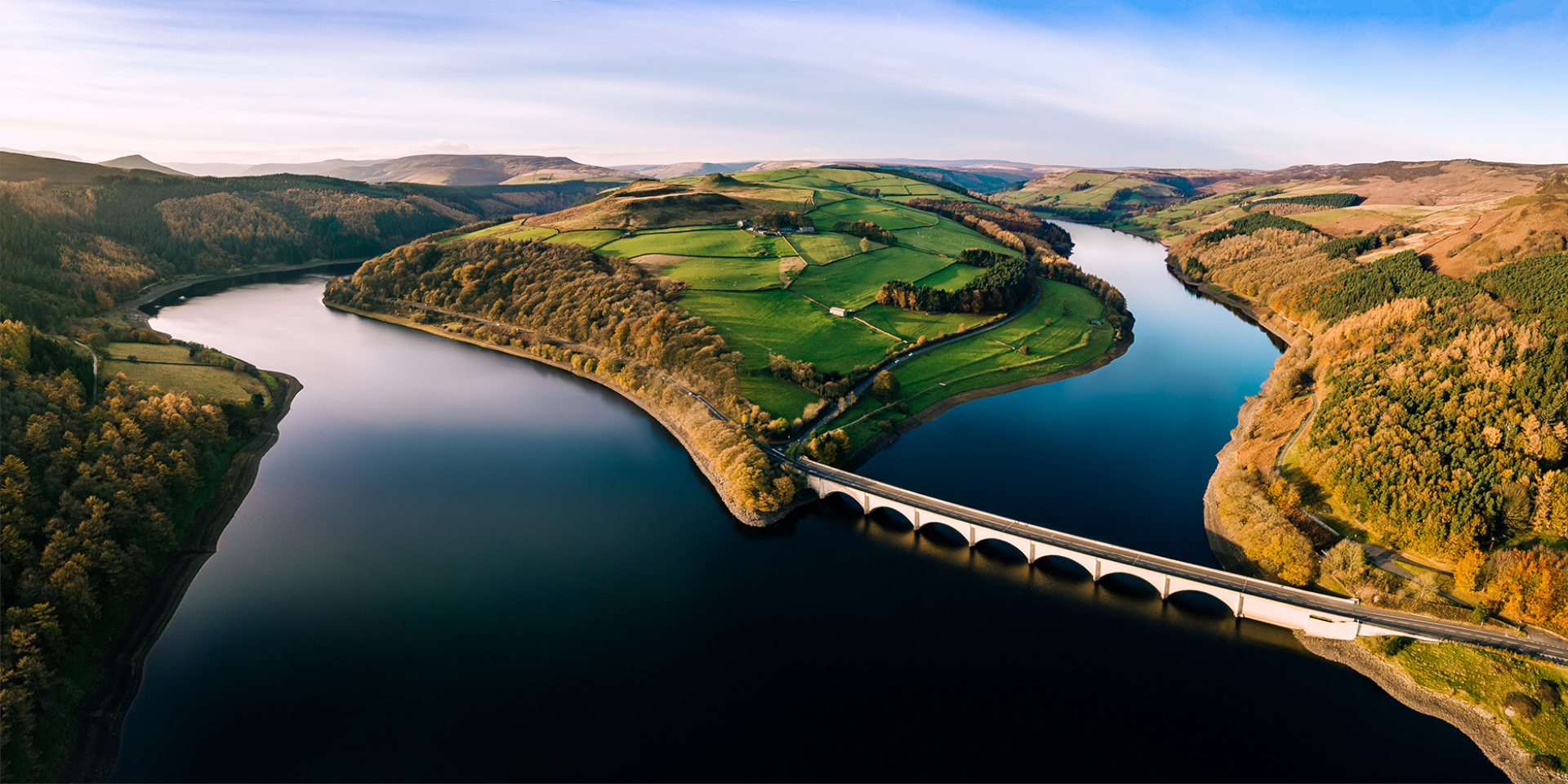 A forked river in the countryside with a bridge.